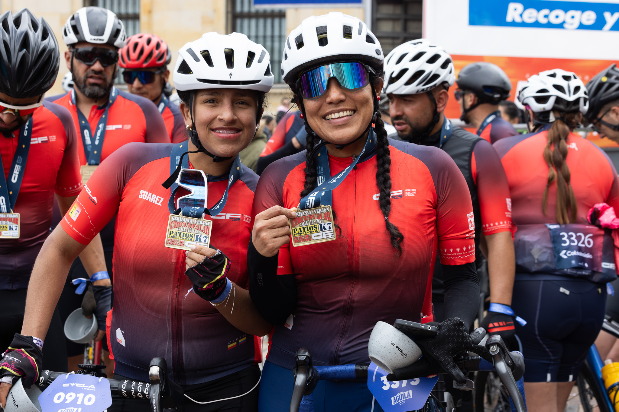 Foto de dos cliclistas mujeres sonreindo y mostrando sus medallas