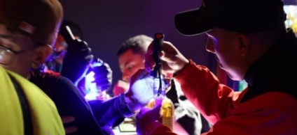 Foto de personas llenando botellas con licor