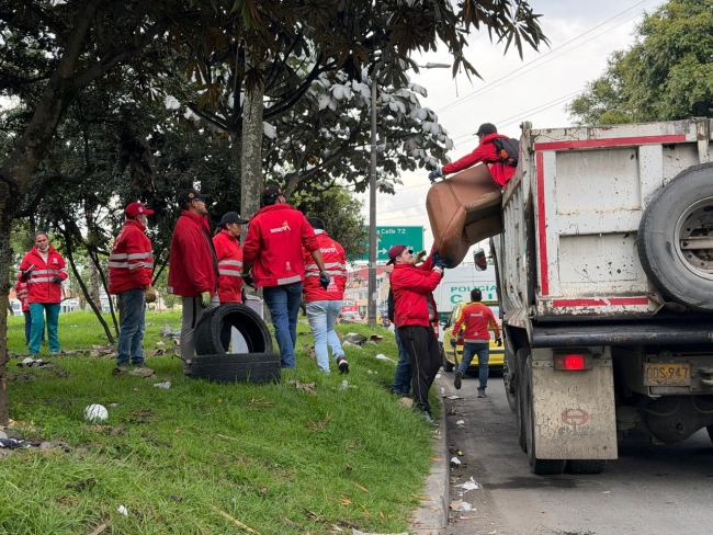 Gestores de la alcaldía local recogiendo basura en una volqueta