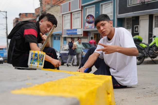 Estudiantes, vecinos, autoridades locales y Policía participan en limpieza y sensibilización frente al Colegio Altamira, con señalización que prohíbe arrojar basura.