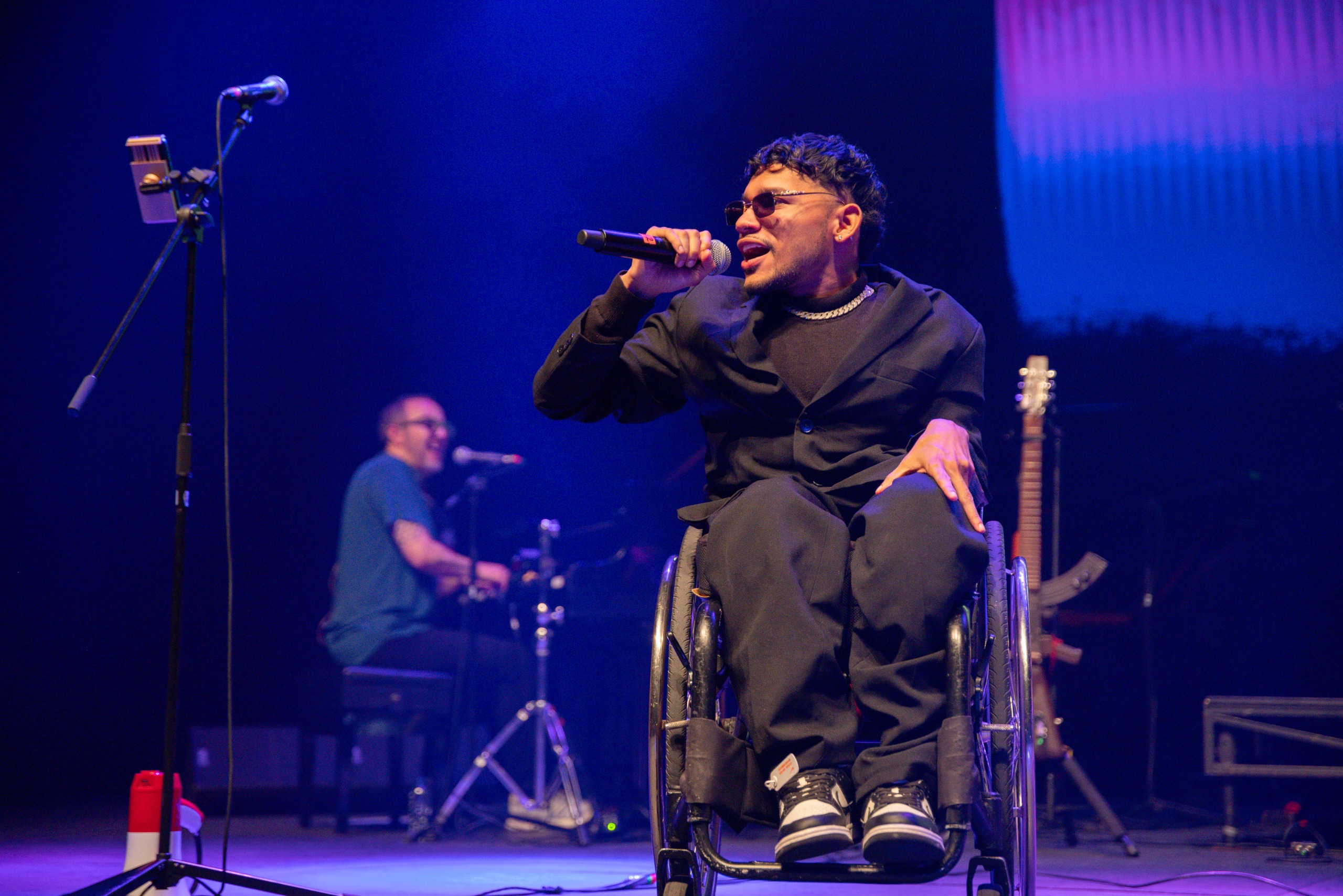 Foto de un participante en silla de ruedas cantando