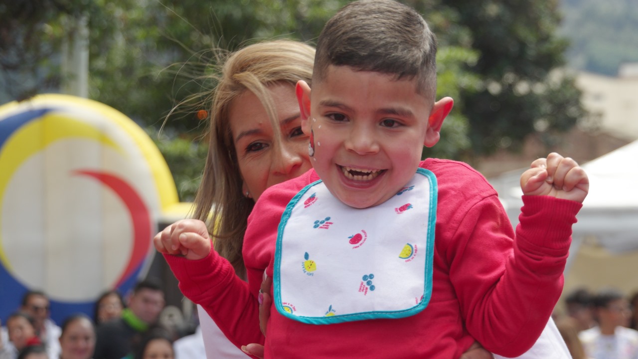 Foto de una señora con un niño especial, ambos están felices