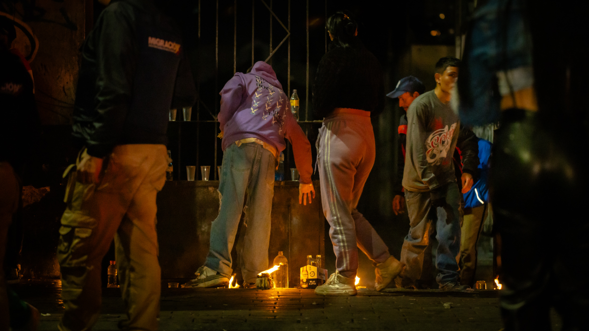Foto de varias personas en la noche cerca de velas colocadas en la calle