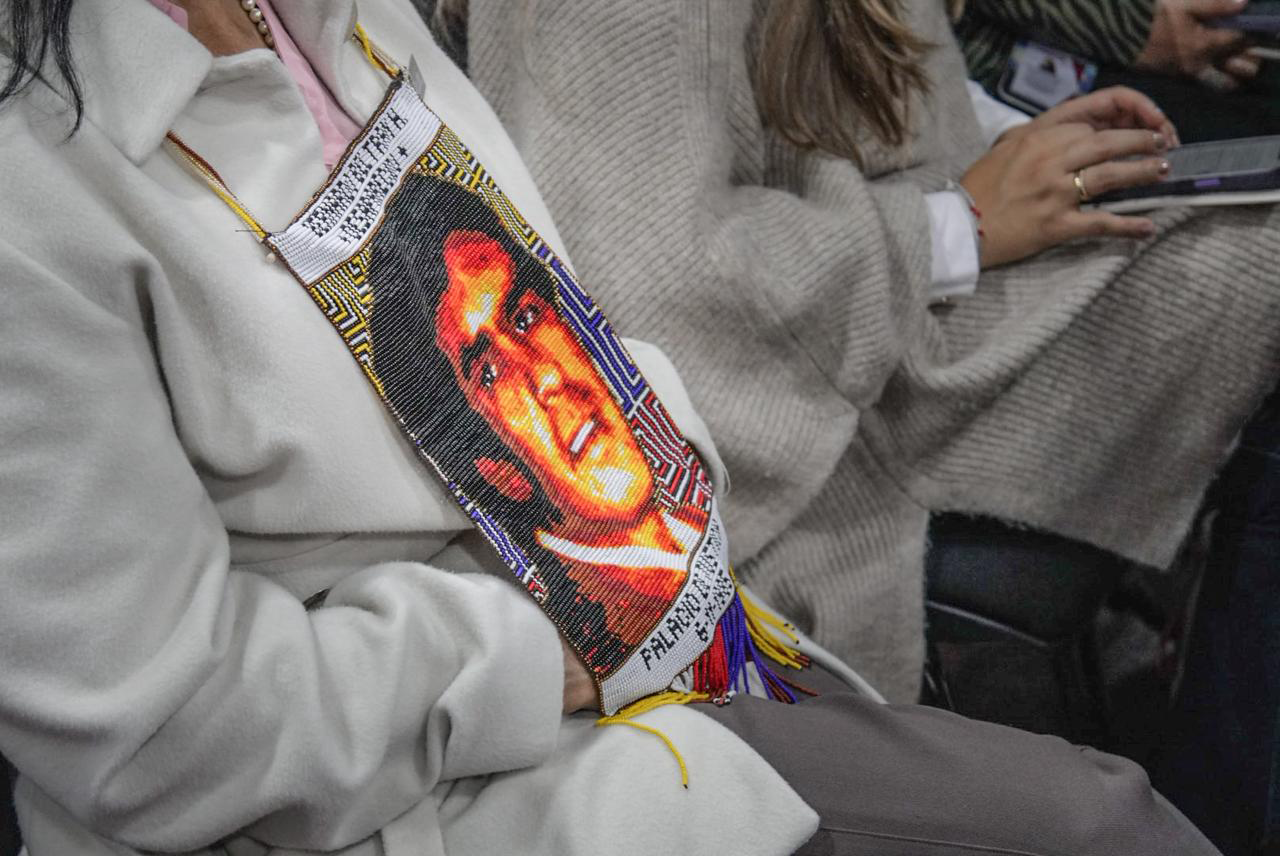 Foto de un saco gris con una ilustración de un rostro.