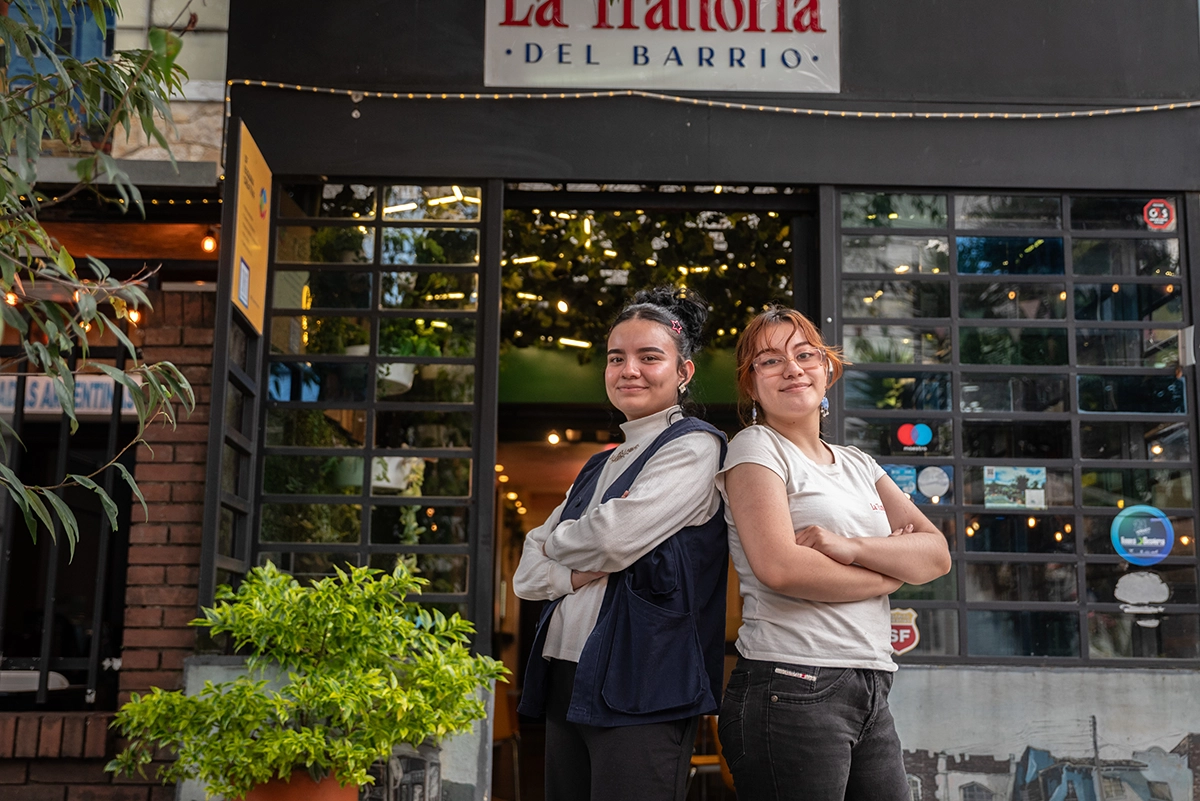Foto de dos jóvenes mujeres frente a su negocio