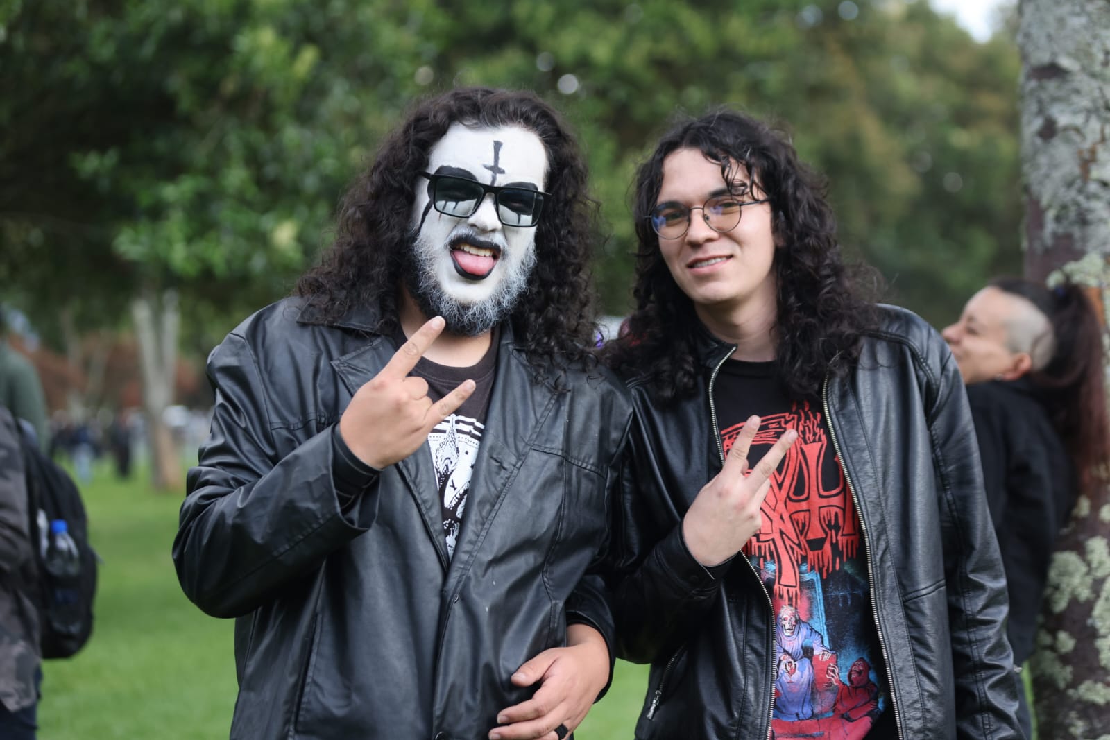 Foto de dos jóvenes con pelo largo y uno maquillado de blanco y negro