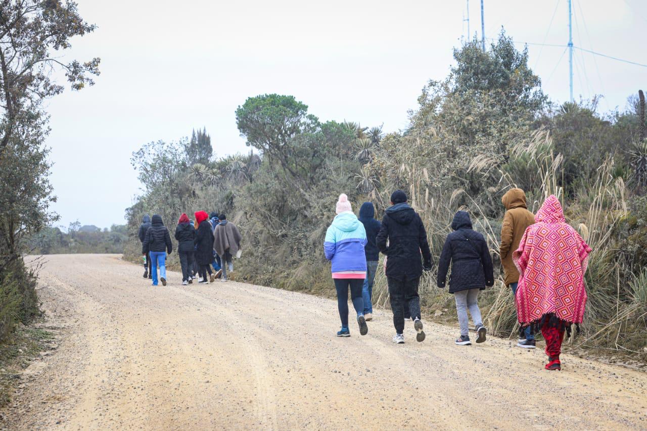 Foto de personas caminando por una carretera de tierra