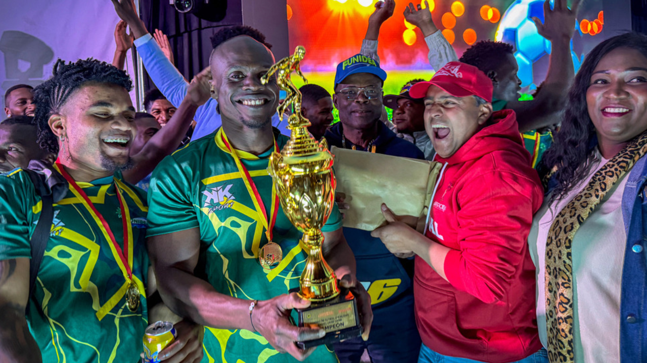 Foto de dos jugadores ganadores del torneo afro recibiendo el trofeo por parte de dos personas.