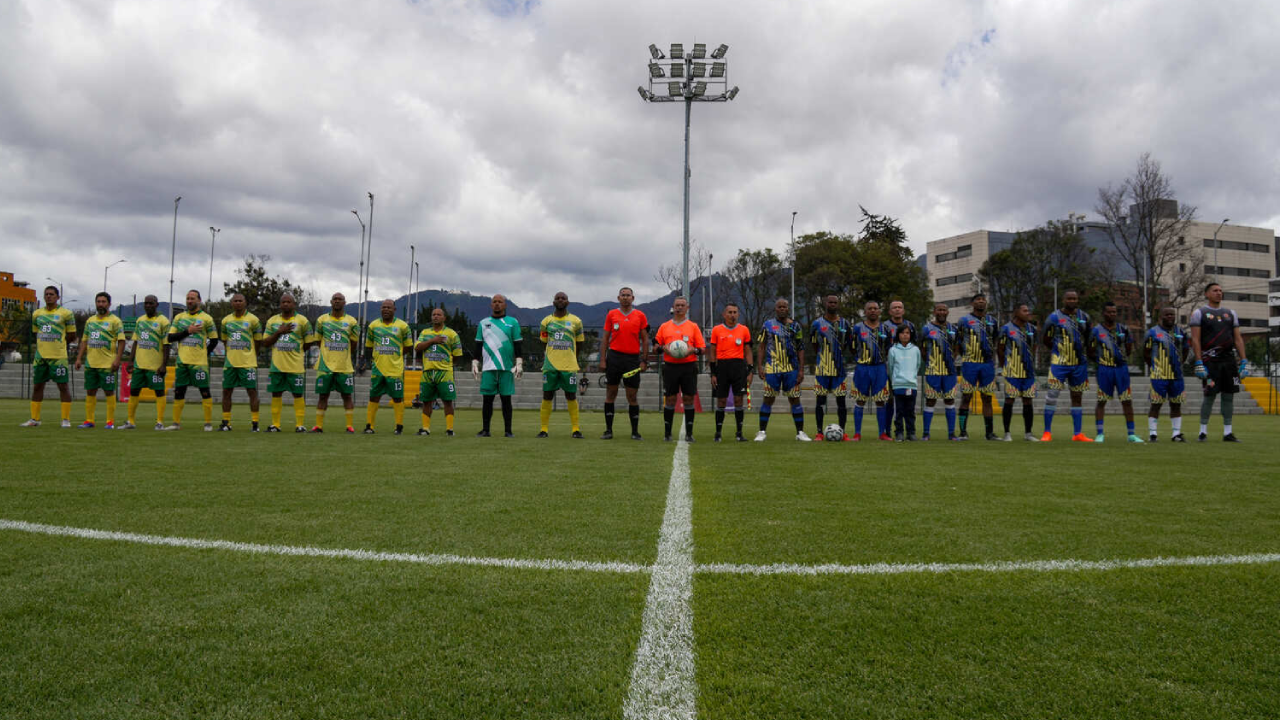 Foto panoramica de dos equipos rivales formados antes de iniciar el partido.