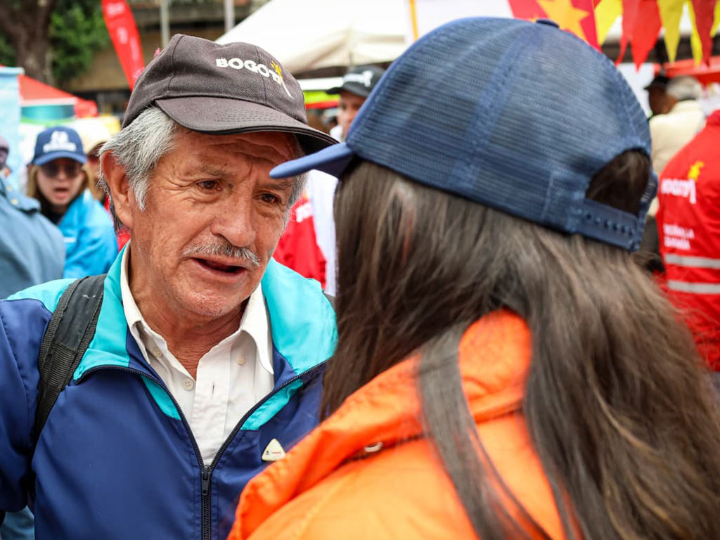 Foto de una persona mayor hablando con una jóven de cachucha azul
