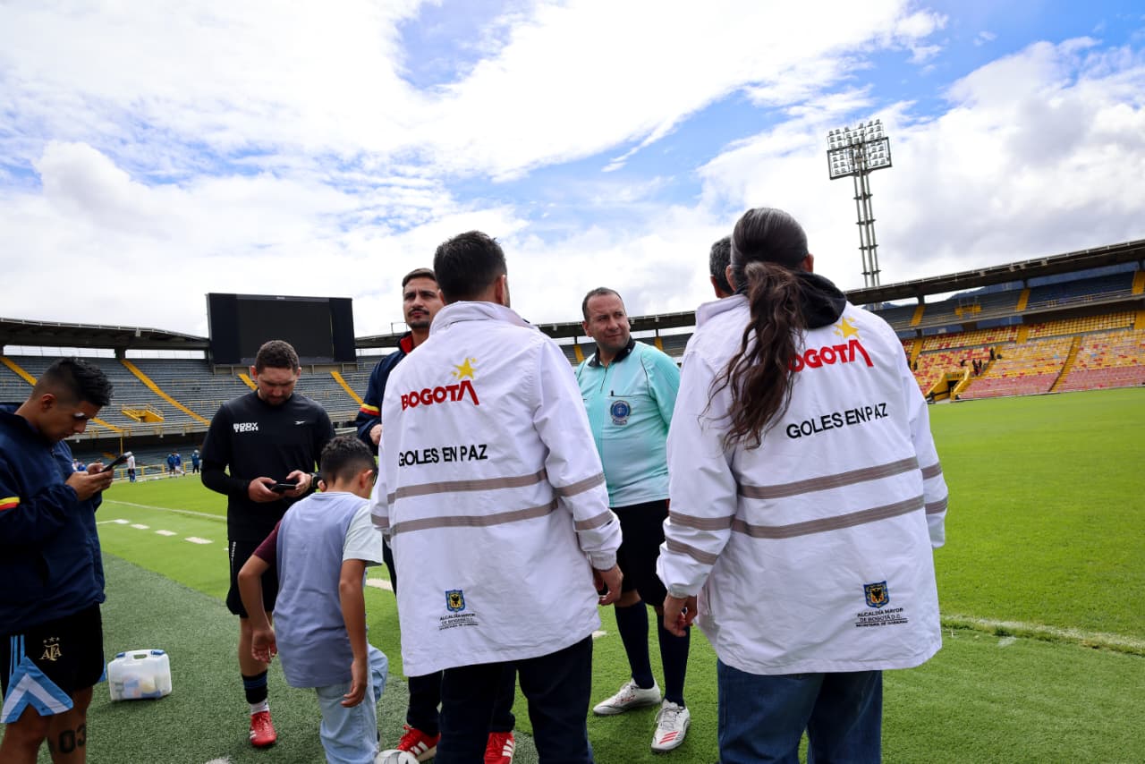 Foto de dos funcionarios del equipo de Goles en Paz hablando con los árbitros