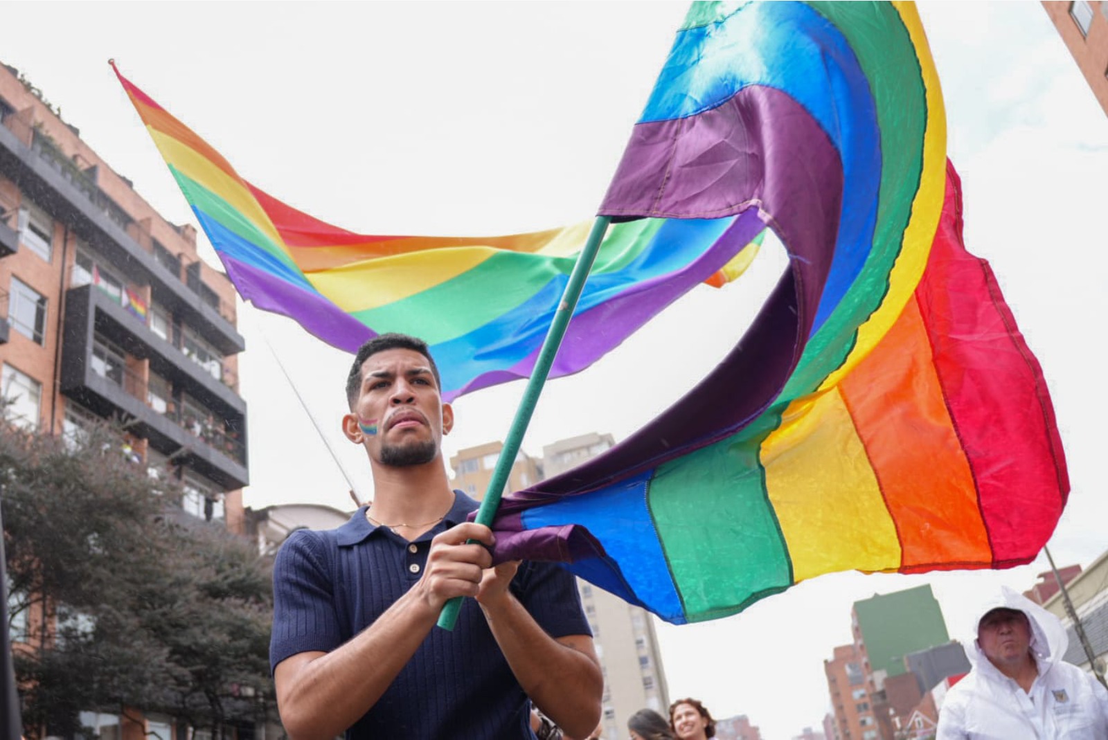 Foto de una persona de la comunidad LGBTI ondeando su bandera