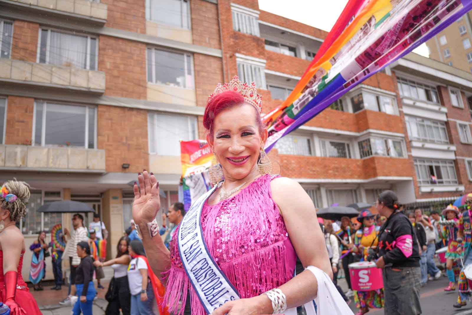 Foto de una persona de la comunidad en la marcha saludando a la cámara