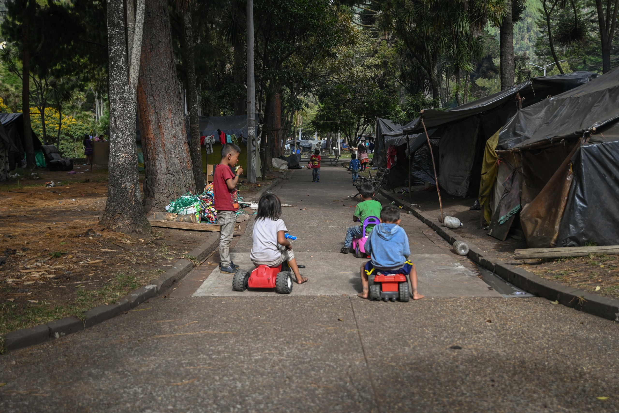 Foto de niños jugando a impuslarse con motos de plastico en uno de los corredores del Parque Nacional de Bogotá