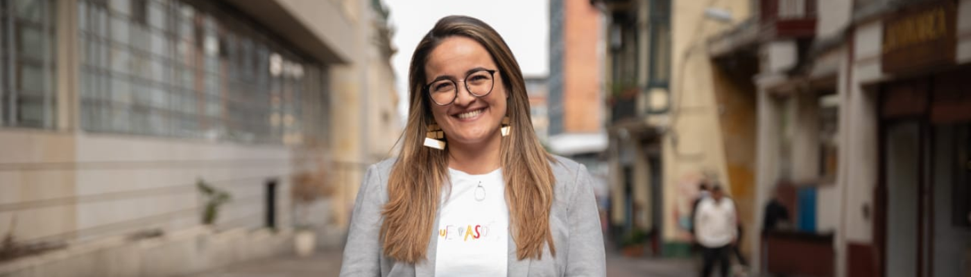 En la foto se encuentra Laura Giraldo sonriendo y de fondo se aprecia la calle 12 en el centro de Bogotá