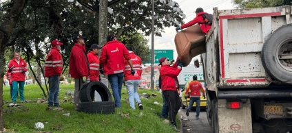 Gestores de la alcaldía local recogiendo basura en una volqueta