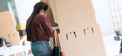 Ciudadana en urna de votación, ejerciendo su derecho al voto.