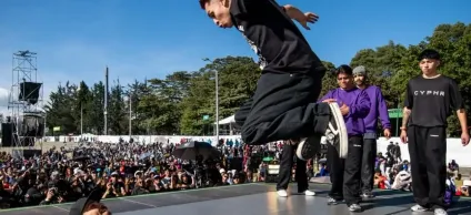 Dos jóvenes sobre la tarima bailando break dance