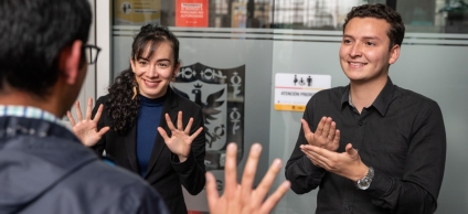 Tres personas comunicándose a partir de lenguaje de señas
