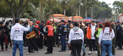 En la fotografía se puede apreciar a tres funcionarias y funcionarios de Diálogo en medio de una manifestación de la ciudadanía.