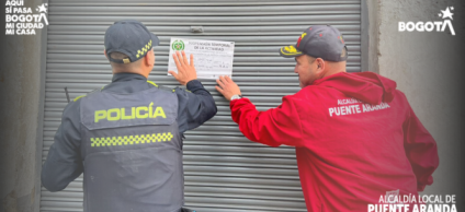 Policía y personal de la Alcaldía cerrando un establecimiento.