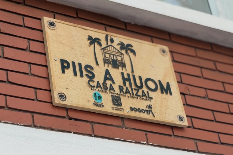 Fotografñia de una placa que dice "Piis a Huom"
