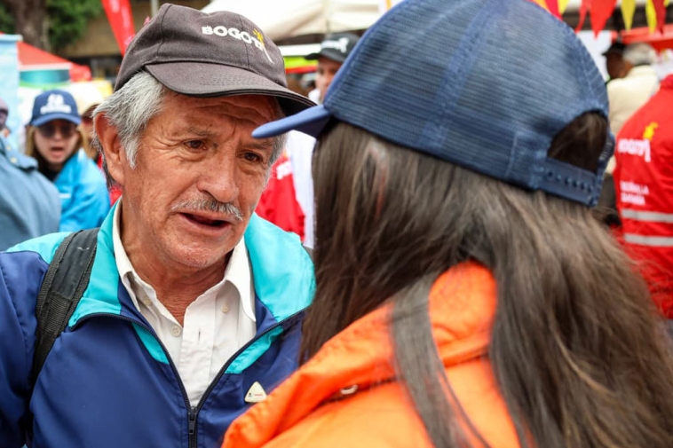 Foto de una persona mayor hablando con una jóven de cachucha azul