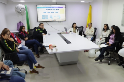 Personas reunidas alrededor de una mesa, entre los que se encuentra la alcaldesa local, discutiendo sobre temas de seguridad en la localidad.