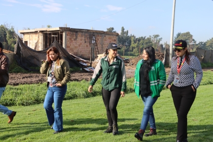 Foto de la alcaldesa local y tres personas más de diferentes entidades caminando en una zona verde ubicada en el humedal Meandro del Say.