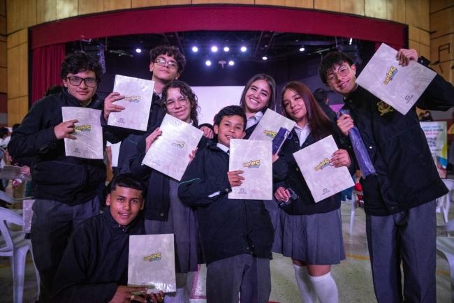 Estudiantes participantes en el cierre de las jornadas pedagógicas de los Consejos Locales de Juventud 2025, sosteniendo la cartilla Grandes por Elección.