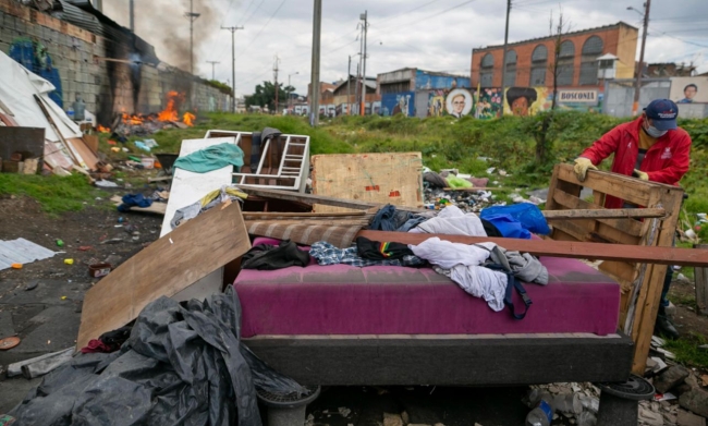 Durante la jornada integral de recuperación del espacio público en la zona de la Carrilera, en la localidad de los Mártires, un gestor retira una cama construida con diferentes materiales reciclados como carretes plásticos y estibas. 