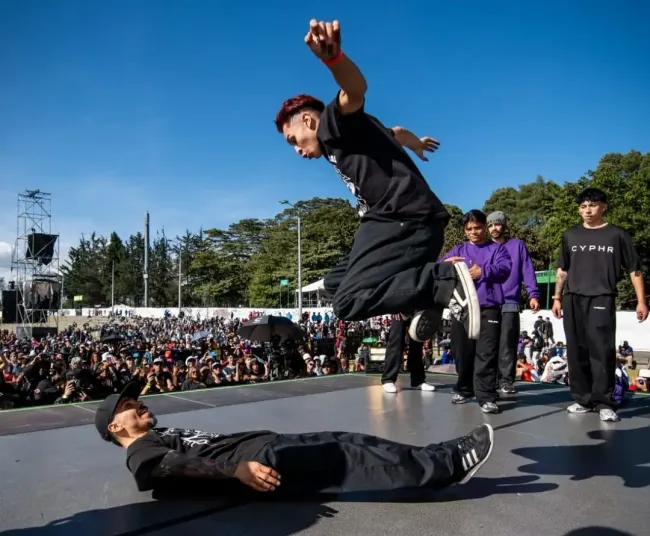 Dos jóvenes sobre la tarima bailando break dance